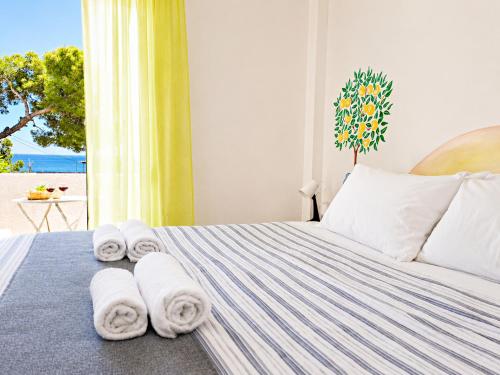 a bedroom with towels on a bed with a window at Kalimera Aegina in Agia Marina Aegina