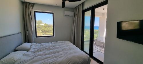 a bedroom with a bed and a large window at TAO House in Ferma