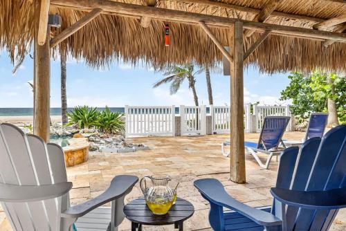 a patio with chairs and a table and the ocean at Gulf Front Dreams in Clearwater Beach