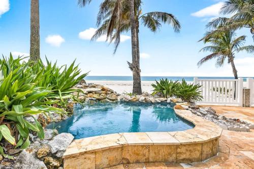 a small swimming pool with a beach in the background at Gulf Front Dreams in Clearwater Beach