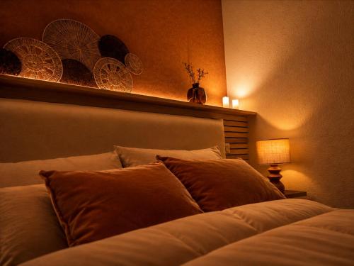a bedroom with a bed with a headboard and a lamp at Evasion Terracotta - Jacuzzi privatif in Saint-Gaudens