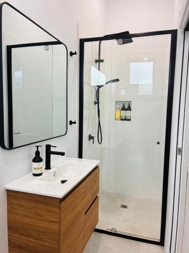 a bathroom with a shower with a sink and a mirror at Sapphire Beach Studio in Sapphire Beach