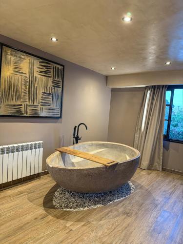 a bathroom with a large stone tub on the floor at Chateau Montchenot in Maipú