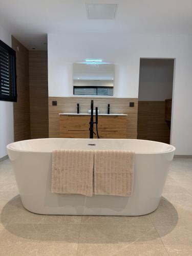 a large white bath tub with two towels on it at L'Annexe de la Subérine in Vivès