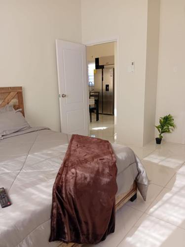 a bedroom with a bed with a blanket on it at Cozy Escape 876 Secure 2BR with AC, Parking & near Beaches in Portmore