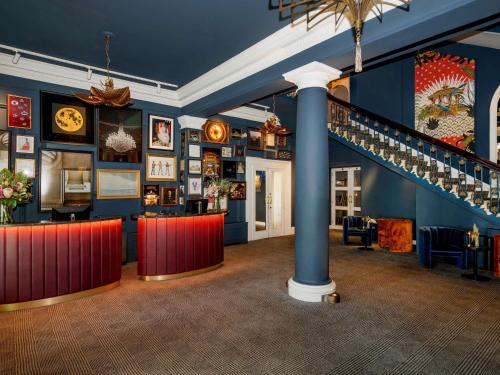 a bar with blue walls and a staircase in a room at Mercure Brighton Seafront Hotel in Brighton & Hove