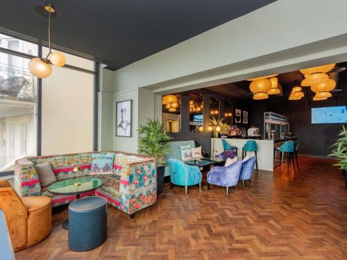 a living room with a couch and chairs and a bar at Mercure Brighton Seafront Hotel in Brighton & Hove
