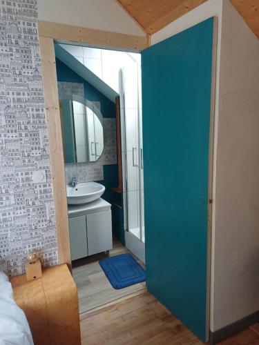 a bathroom with a blue door and a sink at Soleil Bleu in Saint-Racho