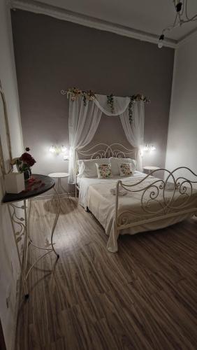 a bedroom with a white bed with a canopy at Sicilia Bedda C&G in Acireale