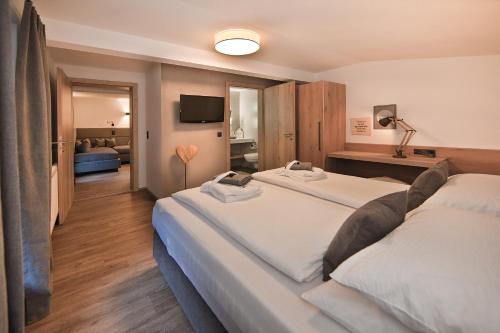 a hotel room with two beds and a television at Villa Michaela in Gerlos
