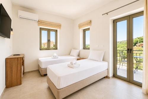 a living room with two beds and a television at Villa Castillo Thio in Agios Nikolaos