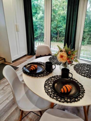 a white table with two plates of food on it at Hegyi Kuckó Vendégház - Forest Hideaway with Jacuzzi in Biatorbágy