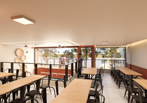a restaurant with wooden tables and chairs and a balcony at Hotel JB in Juazeiro do Norte
