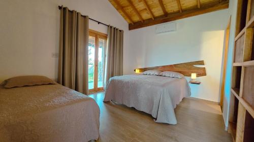 a bedroom with a bed and a window at Reserva Cambucá - Afeto, Pessoas e Sabores in Itirapina