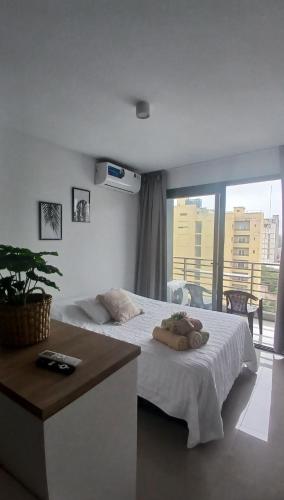 a bedroom with a white bed and a balcony at Centro suite II in Santiago del Estero
