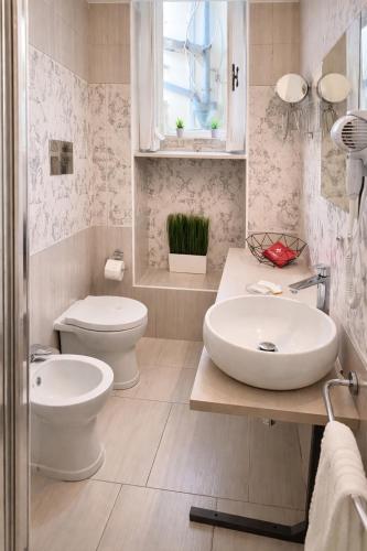 a bathroom with two sinks and a toilet and a window at Lùrooms- Guesthouse in Noto in Noto