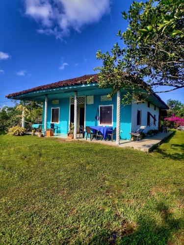 a blue house with a table in a yard at Hotel Casa de Teja in Norcasia