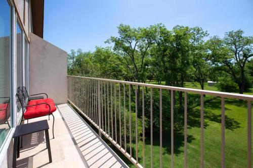 a balcony with a red bench and a field of grass at WW A302 River Relaxation in New Braunfels