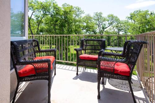 three chairs with red cushions sitting on a balcony at WW A302 River Relaxation in New Braunfels