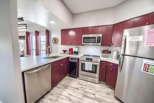 a kitchen with stainless steel appliances and red cabinets at IC 309 Wine Dine in New Braunfels