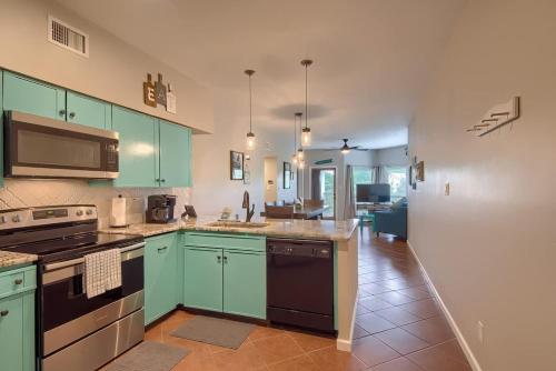 a large kitchen with green cabinets and appliances at IC 302 Ripley River Haus in New Braunfels