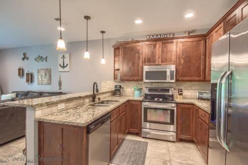 a kitchen with wooden cabinets and stainless steel appliances at RG 105 Rio Refuge in Canyon Lake