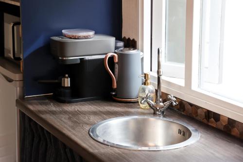 a kitchen counter with a sink and a window at Knus Relaxchalet met Privé Hottub in Voorthuizen