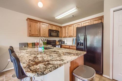 a kitchen with a granite counter top and a black refrigerator at WW H303 Dreams and Streams in New Braunfels