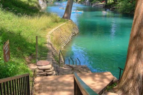 a staircase leading down to a river with green water at CW C101 Condo de Comal in New Braunfels