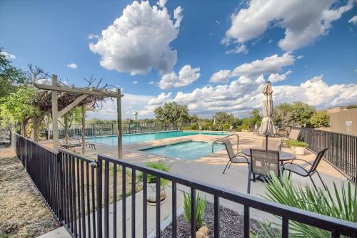 a swimming pool with a deck with chairs and a table at TBM 112 Among The Oaks in New Braunfels