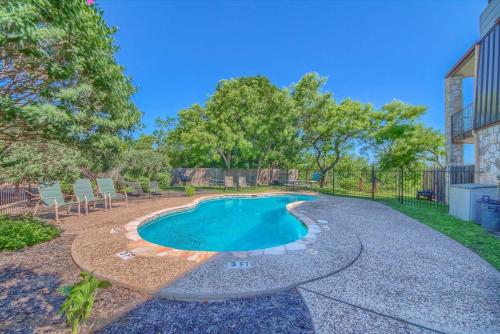 a swimming pool in a yard with chairs and trees at SS B4 Riverside Condo in New Braunfels
