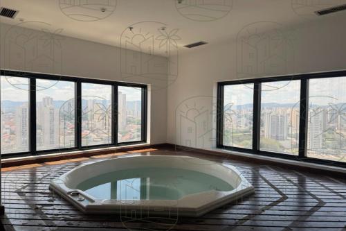 a bath tub in a room with large windows at Flat Executivo em Guarulhos - 6 in Guarulhos
