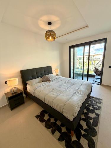 a bedroom with a large bed with a black headboard at Beachfront luxury 2 bedroom appartement with pool and gym in Mansouria