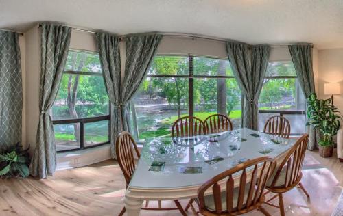 a dining room with a table and chairs and windows at CRC 317 Timeless Tranquility in New Braunfels