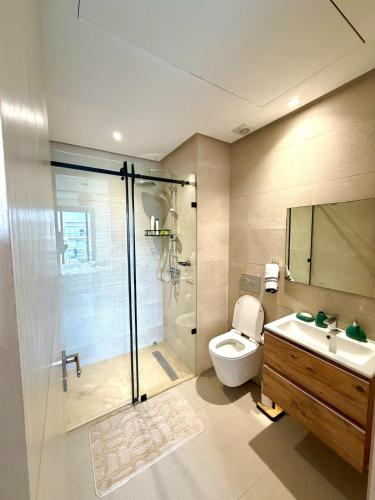 a bathroom with a shower and a toilet and a sink at Beachfront luxury 2 bedroom appartement with pool and gym in Mansouria