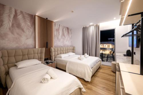 a hotel room with two beds and a balcony at Hotel Resol 2 in Ksamil
