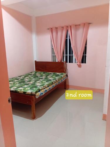 a bed in a room with a window at Bato transient house in Bato