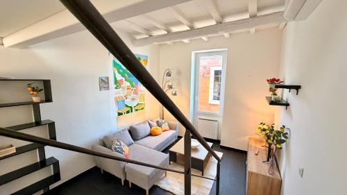 a living room with a couch and a staircase at La Suite Limoncello, Sunny & Spacious in Nîmes