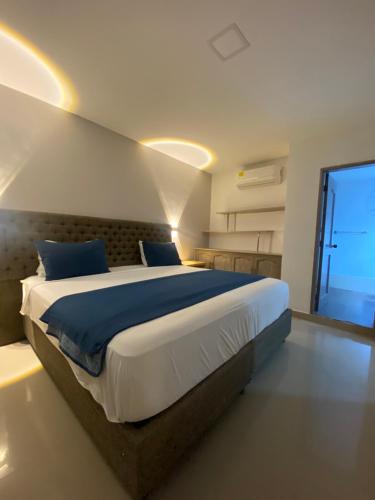 a bedroom with a large bed and a large window at Hotel Yivinaca in Barranquilla