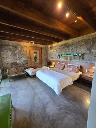 a bedroom with two beds in a stone wall at Linda Casa in Isla Tzilinabaj