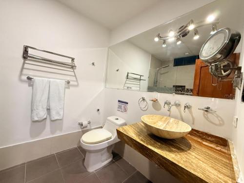 a bathroom with a sink and a toilet and a mirror at Hotel Yivinaca in Barranquilla