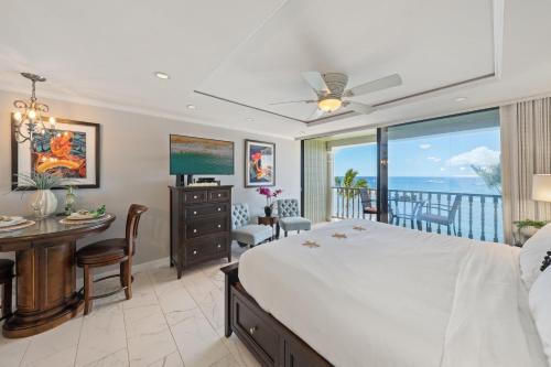 a bedroom with a bed and a dining room with a balcony at Lahaina Shores 511 in Lahaina