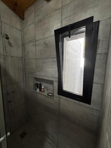 a bathroom with a shower with a window at La Pausa Córdoba, casa en Los Reartes in Los Reartes