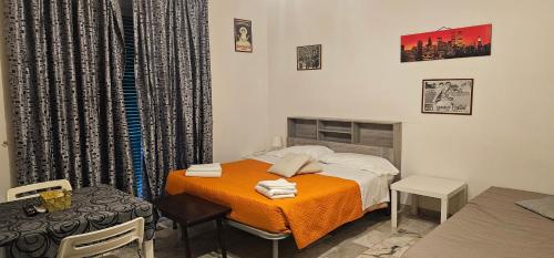 ein kleines Zimmer mit einem Bett und einer orangefarbenen Decke in der Unterkunft Affittacamere Nilo in Neapel
