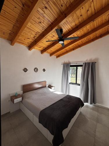 a bedroom with a bed and a wooden ceiling at La Pausa Córdoba, casa en Los Reartes in Los Reartes