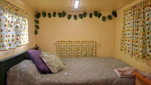 a small bedroom with a bed and curtains at Truck Caravan Rustic Sunflower in Mount Crosby