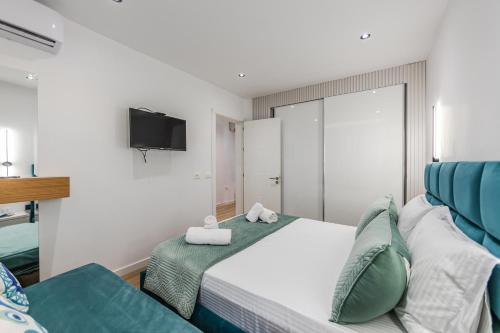 a bedroom with a bed and a couch and a television at The Garden Jacuzzi Apartment By PS in Golem