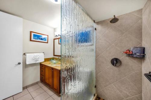 a bathroom with a glass shower with a sink at Lahaina Shores 631 in Lahaina