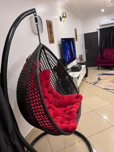 a hammock in a living room with a red cushion at New Luxury in Gwarinpa
