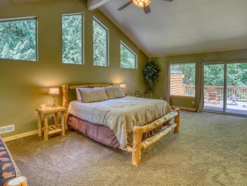 a bedroom with a bed in a room with windows at Salmon River Chalet - Meredith Lodging in Welches